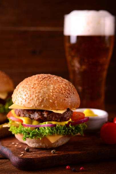 istock Fresh burger closeup and beer. Wooden rustic background. Top view 940168070
