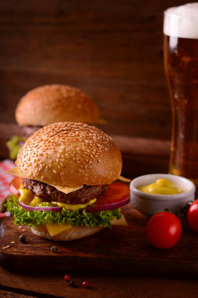 istock Fresh burger closeup and beer. Wooden rustic background. Top view 940168194