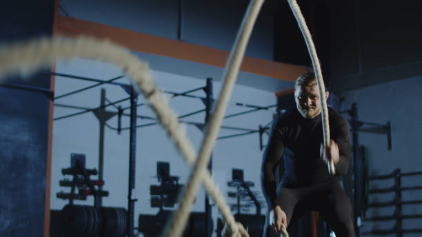 istock Athlete working out with heavy ropes in gym 940176376
