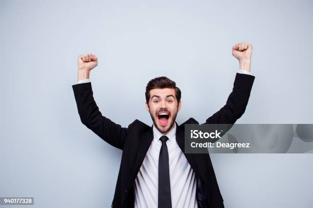 Happy Excited Man Triumphing With Raised Fists On Gray Background Stock Photo - Download Image Now