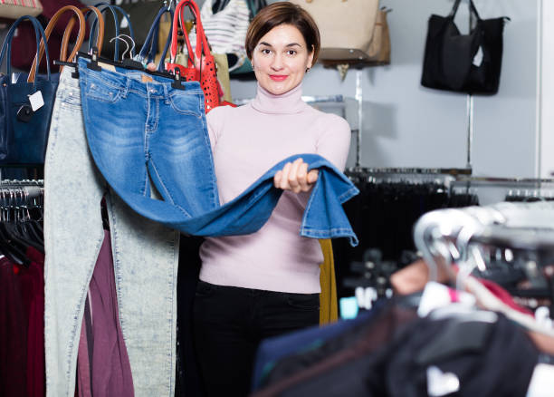 istock Positive girl deciding on new jeans 940177980