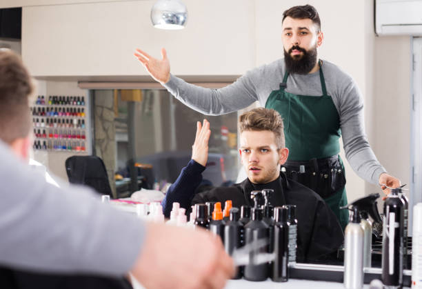 client feeling discontent about his new haircut at hair salon adult spanish client feeling discontent about his new haircut at hair salon angry hairstylist stock pictures, royalty-free photos & images
