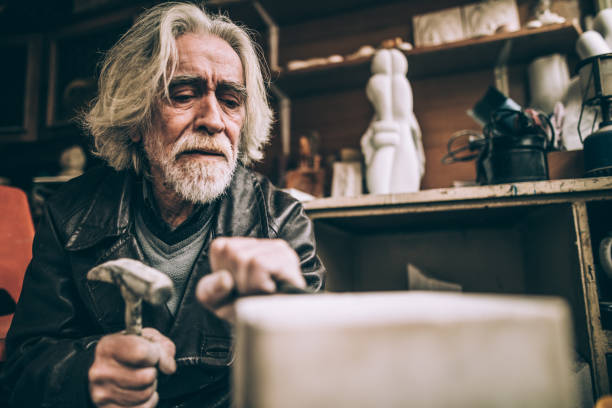 istock Senior artist working with marble at his workshop 940181954