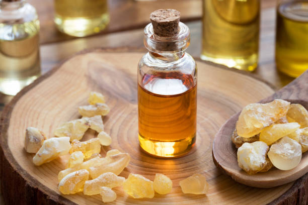 a bottle of frankincense essential oil with frankincense resin - tree resin imagens e fotografias de stock