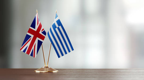 istock British And Greek Flag Pair On A Desk Over Defocused Background 940185914