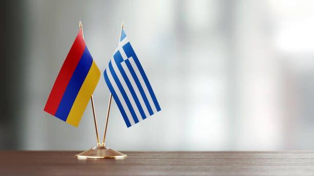 istock Armenian And Greek Flag Pair On A Desk Over Defocused Background 940189730