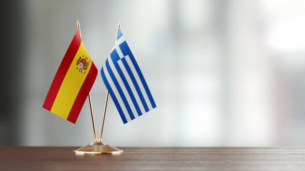 istock Spanish And Greek Flag Pair On A Desk Over Defocused Background 940189980