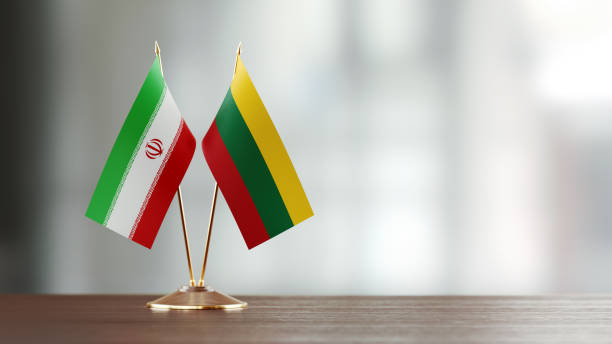 istock Iranian And Lithuanian Flag Pair On A Desk Over Defocused Background 940192356