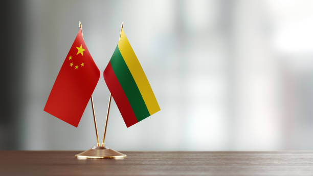istock Chinese And Lithuanian Flag Pair On A Desk Over Defocused Background 940193668