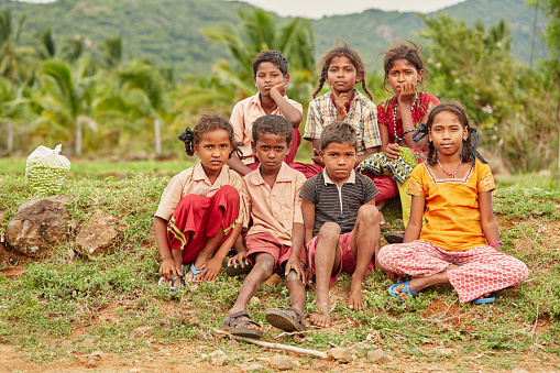 Group of teen village friends sitting on farm land In Tamil nadu village.