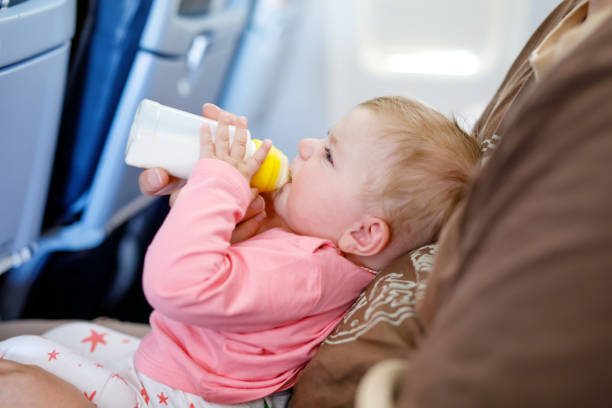 istock Father holding his baby daughter during flight on airplane going on vacations 940198284