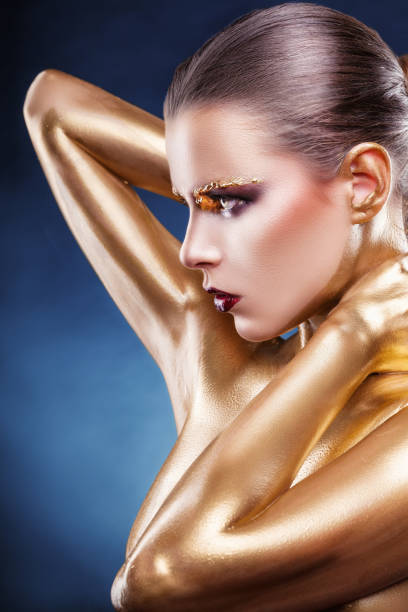 Beautiful gold girl. Fashion woman with golden makeup and bodyart