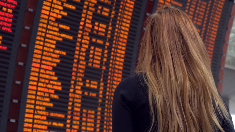 Woman looking at arrival departure board