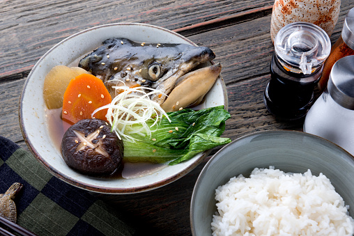 Salmon head in soya soup steamed with ingredient in Japanese style food.