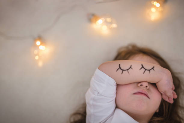 Cute toddler girl enjoying her time on a fresh clean bed.