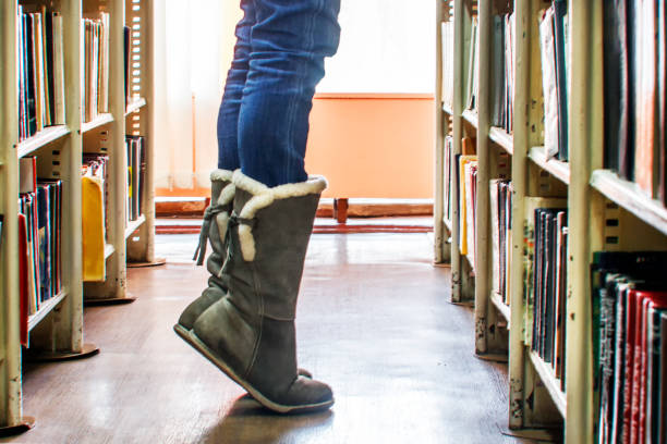 istock The student reaches for the book on the top shelf in the library 940208440