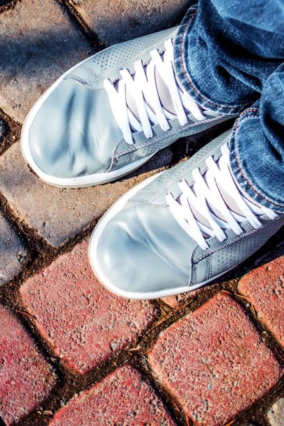 istock Legs in jeans and sneakers 940213300