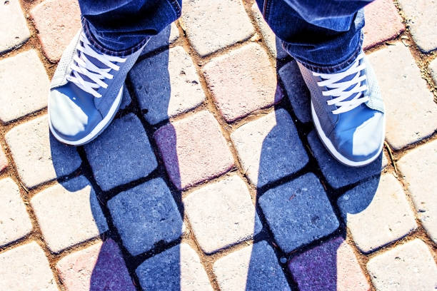 istock Legs in jeans and sneakers 940213312
