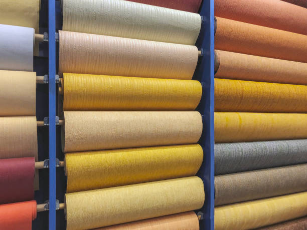 istock Colored wallpaper rolls on store shelves. Paper material for repair 940214030