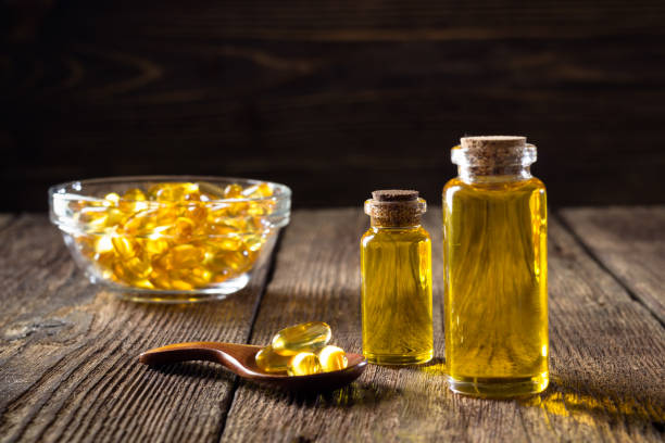 Fish oil capsules on wooden background.