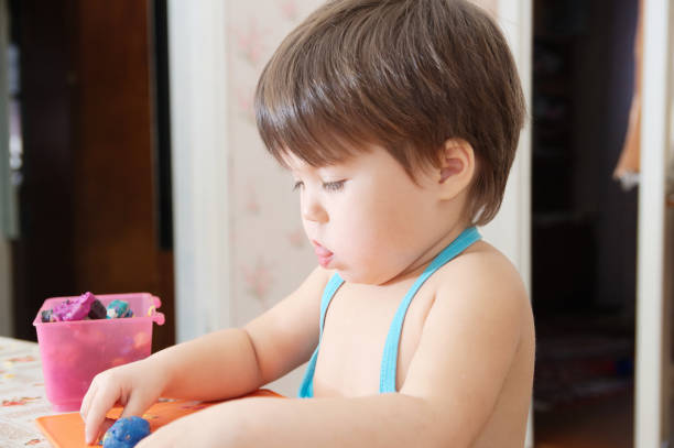 istock Little girl playing with plasticine forming figure 940216984