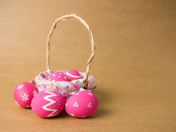 istock Easter eggs in a basket weave wood on the left corner on a brown background. 940217430