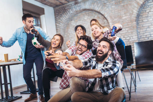 istock Coworkers playing video games in office 940231516