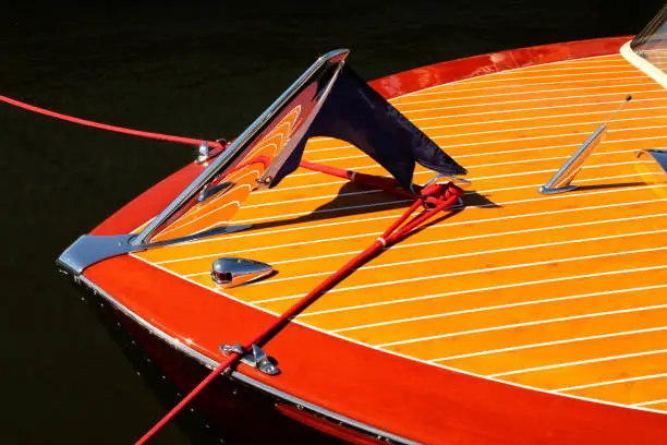 Photo of Bow of vintage wooden boat with crome reflecting wood stripes - red and yellow