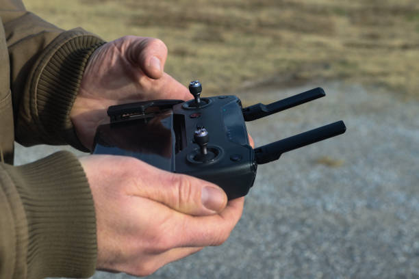 Hands holding controller for drone that uses a cell phone in the winter - selective focus