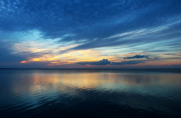 Almost Sunset South Padre - Very blue clouds with sunset appearing on the horizon all reflected in the ocean