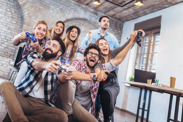 istock Coworkers playing video games in office 940235240