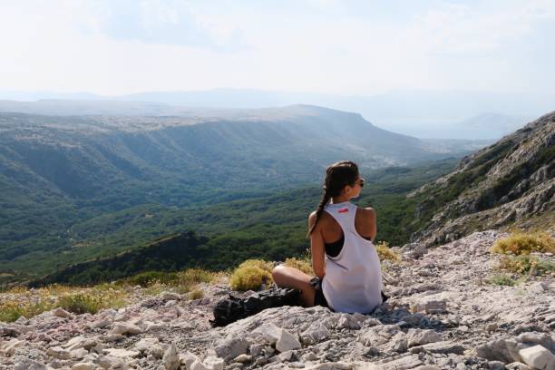 istock Young woman standing on the edge / cliffs / mountains 940236746