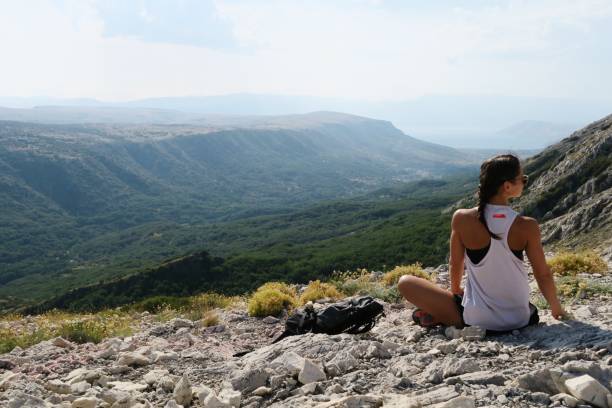 istock Young woman standing on the edge / cliffs / mountains 940236780