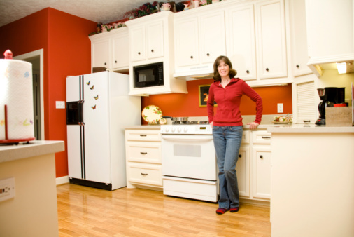 Mature woman in jeans in kitchen.