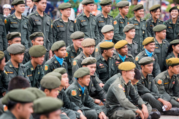 Thai army people at the tradititional Longboat Race at the Mun river of the town of Satuek north of the city Buri Ram in Isan in Northeast thailand.  Thailand, Buriram, November, 2017