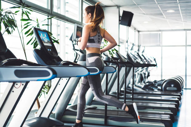 femme fitness, faire une séance de cardio sur un tapis roulant - treadmill photos et images de collection