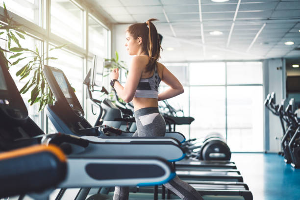 istock Fitness girl running on a treadmill 940258474
