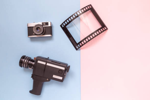 istock Flat lay of old fashioned camcorder, camera and photo frame against pastel background minimalistic concept. 940258584
