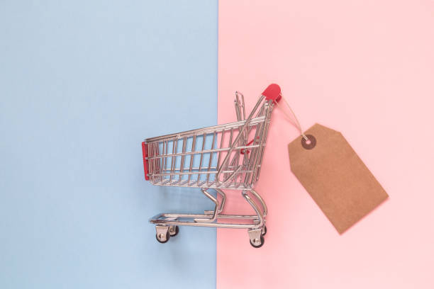 istock Shopping trolley toy with special offer tag on pastel background minimalistic flat lay concept. 940258954