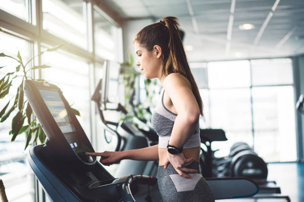 istock Fit woman choosing a cardio workout on a treadmill 940259308