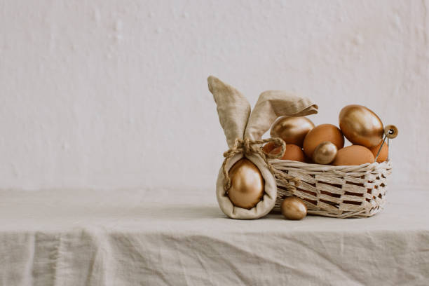 istock Rustic Happy Easter. Funny eggs with linen napkin on Rural background 940264178