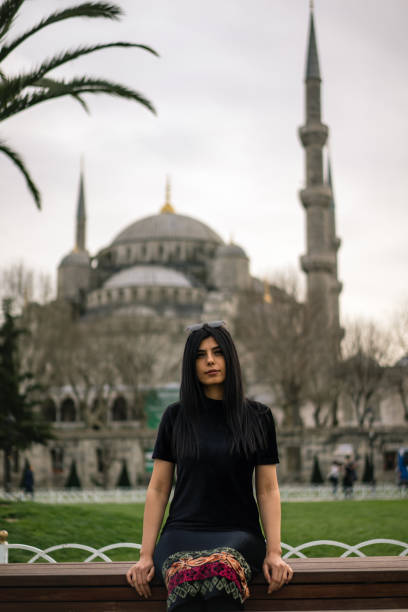 women sit near mosque