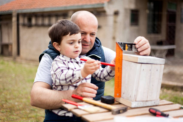 istock Father and son building birdhouse outdoor 940268026