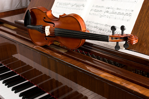 Violin on grand piano with notes