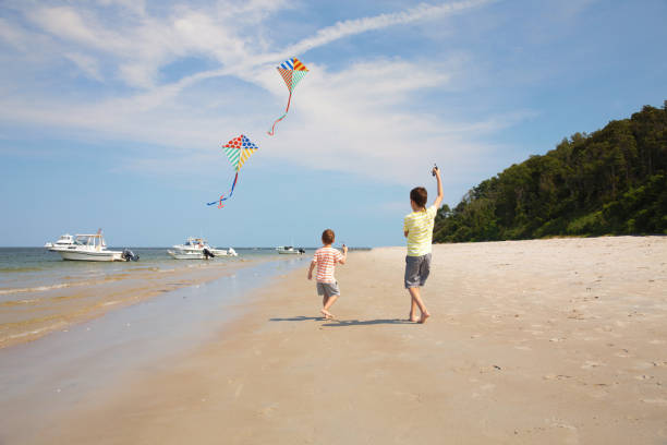 istock children launch kites on the beach 940280156