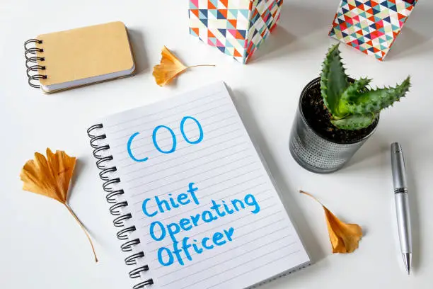 Photo of COO- Chief Operating Officer written in a notebook
