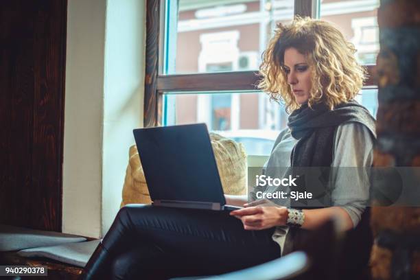 Woman With Curly Hair Working Seriously On Her Laptop Stock Photo - Download Image Now