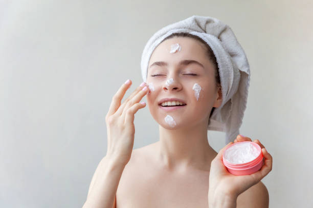 istock Woman applying mask or creme on face 940299432