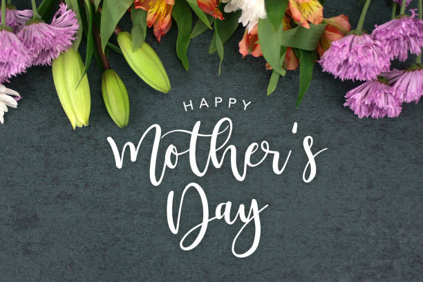 istock Spring season still life with Happy Mother's Day greeting holiday script over dark blackboard background 940300304