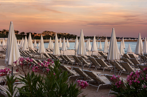 Rows of lounge chairs and umbrellas await sunbathers on the French Riviera in Cannes, France.
